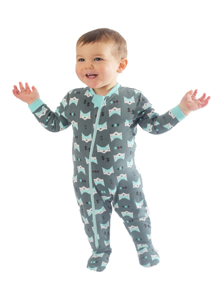 cute light skinned toddler wearing green cotton baby sleeper with fox head and pine tree imagery